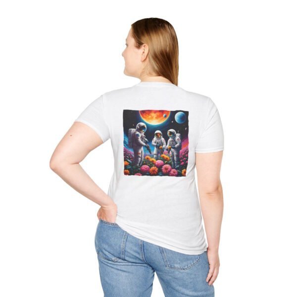 A young woman wearing a white T-shirt featuring a vibrant graphic of three astronauts in spacesuits watering colorful flowers under a celestial sky planets