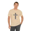 A male model wearing a cream colored "Believe 3:16", with a 3D stacked cross graphic and the words "Believe" and "John 3:16" on the front.