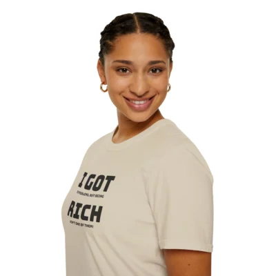 Female model wearing a sand colored "I Got 99 Problems, But Being Rich Ain't One of Them!" T-shirt, left front viewpoint.