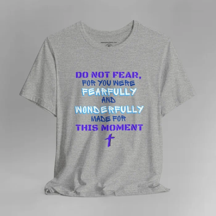 A athletic heather colored tee with the words "Do Not Fear, For You Were Fearfully and Wonderfully Made For This Moment" in varying fonts and colors (purple, deep blue, and light aqua blue). There is a graphic, artistic purple cross beneath the words.