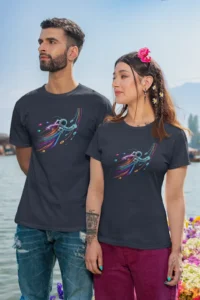 Male and female models wearing the navy colored "Neon Astronaut Lightspeed Unisex Tee" from Big Baby Gorilla Bear. Featuring a neon outlined astronaut, flying through space with vibrant neon blue, pink, and yellow-orange colors (front of shirt). 