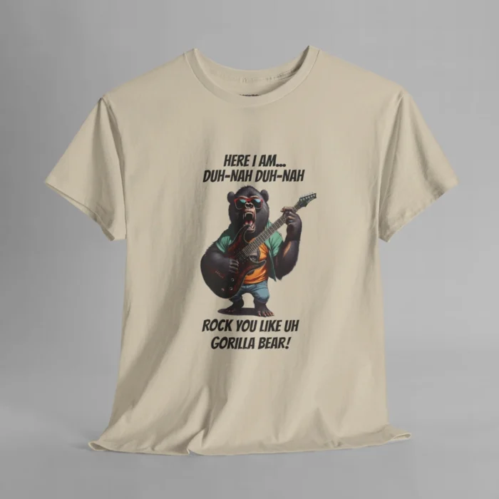 A sand colored t-shirt mockup of a gorilla bear creature, dressed a green button up, an orange undershirt graphic tee, and blue jean shorts and shades, holding an electric guitar. The text on the shirt says "Here I am...Duh-Nah Duh-Nah Rock you like a Gorilla Bear"