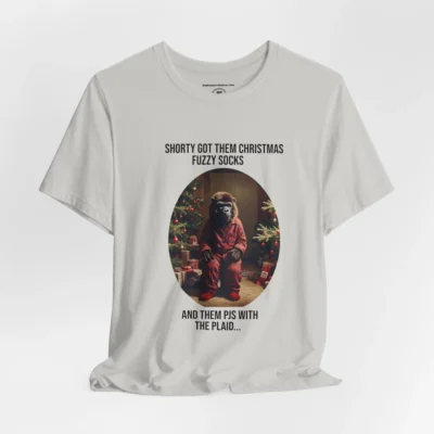 Vertical Layout of a tee showcasing the "Shorty PJs With the Plaid" BigBabyGorillaBear.Com Silver colored graphic tee! This tee has a Big Baby Gorilla Bear with plaid PJs and fuzzy socks in a Christmas scene, with the words "Shorty Got Them Christmas Fuzzy Socks and Them PJs with the Plaid..."
