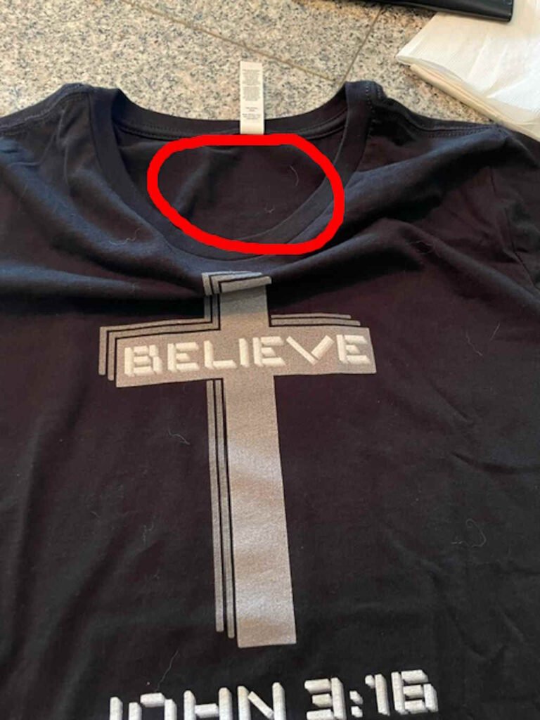 Another image showing the main graphic of the shirt, and the inner tag - highlighting with a red circle that the product brand label is missing.