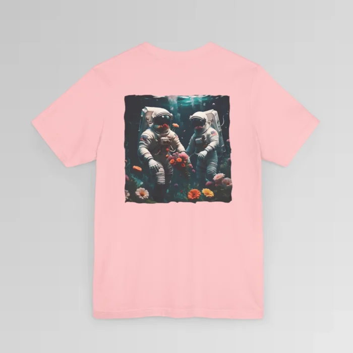 A pink shirt with a surreal image on the backside of a tee of two astronauts in space suits walking on an ocean floor, with colorful coral, purple, white, peach, and yellow flowers.