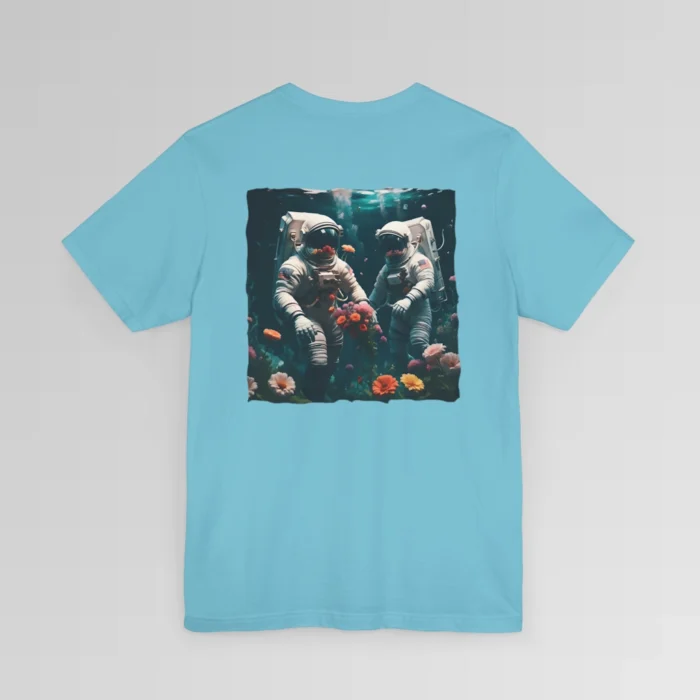 A turquoise shirt with a surreal image on the backside of a tee of two astronauts in space suits walking on an ocean floor, with colorful coral, purple, white, peach, and yellow flowers.