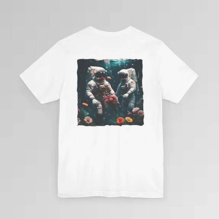 A white shirt with a surreal image on the backside of a tee of two astronauts in space suits walking on an ocean floor, with colorful coral, purple, white, peach, and yellow flowers.