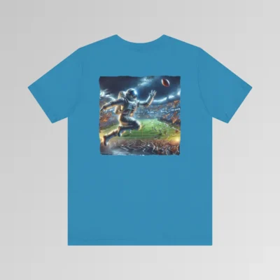An aqua colored graphic tee with an image of an astronaut leaping high above crowds in a football stadium at night, about to catch a football, on the back of the tee. The background is warped, as if the astronaut is moving at super-human speeds.