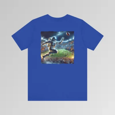 A true royal colored graphic tee with an image of an astronaut leaping high above crowds in a football stadium at night, about to catch a football, on the back of the tee. The background is warped, as if the astronaut is moving at super-human speeds.