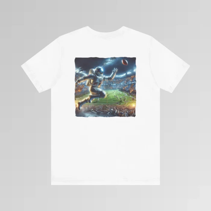 A white colored graphic tee with an image of an astronaut leaping high above crowds in a football stadium at night, about to catch a football, on the back of the tee. The background is warped, as if the astronaut is moving at super-human speeds.