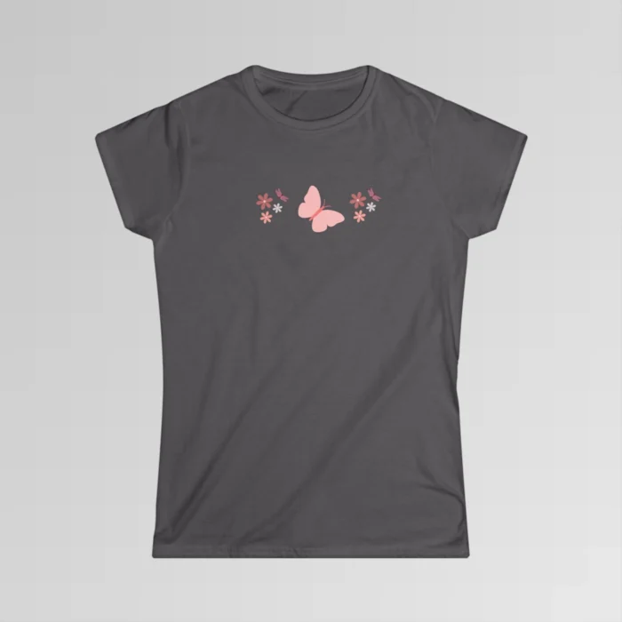 A charcoal colored shirt with a pink butterfly with a coral-colored body in the center, and pink, white, and blush colored flowers, and blush colored dragonflies...in a pattern going vertically across the tee.