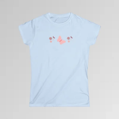 A light blue colored shirt with a pink butterfly with a coral-colored body in the center, and pink, white, and blush colored flowers, and blush colored dragonflies...in a pattern going vertically across the tee.