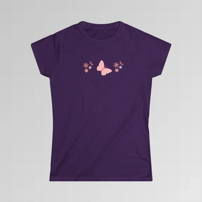 A purple colored shirt with a pink butterfly with a coral-colored body in the center, and pink, white, and blush colored flowers, and blush colored dragonflies...in a pattern going vertically across the tee.