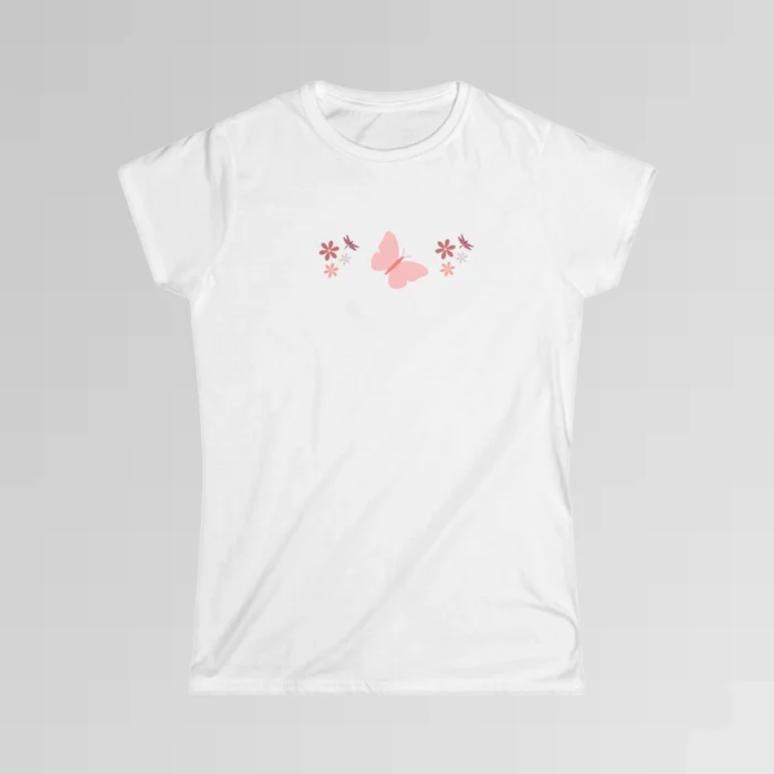 A white colored shirt with a pink butterfly with a coral-colored body in the center, and pink, white, and blush colored flowers, and blush colored dragonflies...in a pattern going vertically across the tee.