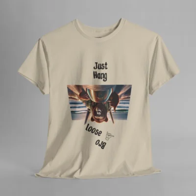 A sand colored graphic tee with one of our iconic bear-gorilla hybrid creatures riding on top of a fighter over a beach. The image is turned upside down, and in the shape of an upside down trapezoid. Above the image is writing that says " Just Hang", and beneath the image it says "Loose Bro" at an angle, and with a hang-loose hand gesture clip art.