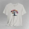 A silver t-shirt with a graphic image of a blued liquid metal tree, with leaves of orange, pink, coral, and magenta on the front of the t-shirt.