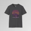 A dark heather shirt with a view of the Miami, FL skyline (not necessarily an accurate view), with a blind effect, as if it appears as if the viewer is looking through window blinds. At the bottom is a generic 1980's style convertible, and a speed boat. Beneath the image says "1980's Mode" . The image has pinks, oranges, greys, purples, and some yellows.