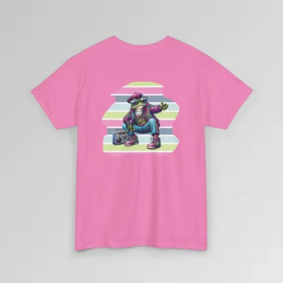 An azalea colored t-shirt mockup with a 1980's styled anthropomorphic frog, wearing pants, shoes, hat, and jacket with shades. The frog is kneeling by a beatbox, and there is a non-symmetrical backdrop with varied colored lines in a ship-lap pattern. Shirt graphic colors are pinks, greens, blues, purples, steel blues, light blues, and white and cream colors.
