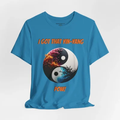 An aqua t-shirt with a Black and white yin-yang, that appears to have trees growing out of the center. The trees are orang and pink, and blacked out. The bottom part of the yin-yang has blue swirls. "I Got That Yin-Yang" is above the image. "Pow!" is beneath the image. The graphic is on the front of the shirt.