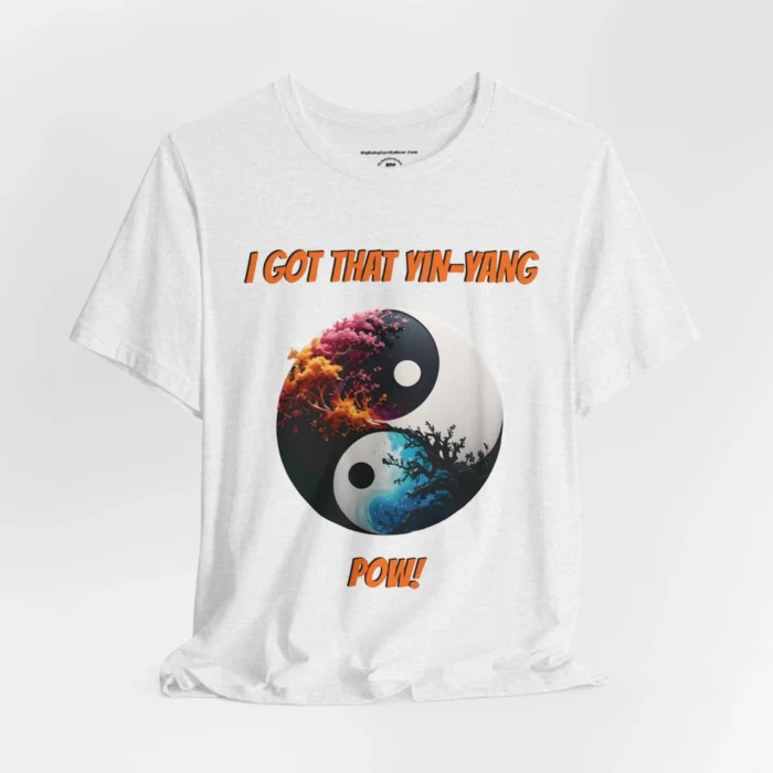 An ash t-shirt with a Black and white yin-yang, that appears to have trees growing out of the center. The trees are orang and pink, and blacked out. The bottom part of the yin-yang has blue swirls. "I Got That Yin-Yang" is above the image. "Pow!" is beneath the image. The graphic is on the front of the shirt.