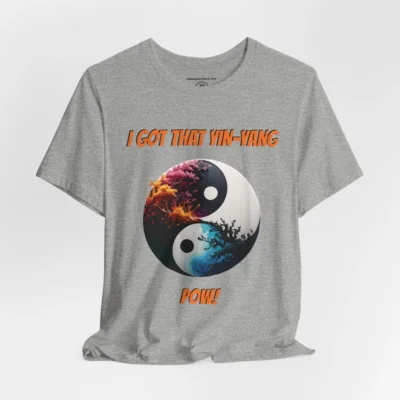 An athletic heather t-shirt with a Black and white yin-yang, that appears to have trees growing out of the center. The trees are orang and pink, and blacked out. The bottom part of the yin-yang has blue swirls. "I Got That Yin-Yang" is above the image. "Pow!" is beneath the image. The graphic is on the front of the shirt.