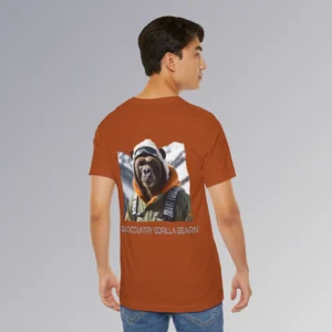 A male model showing the backside of the autumn colored BigBabyGorillaBear.Com "Backcountry Gorilla Bearin'" t-shirt. This shirt features one of our iconic gorilla grizzly bears, fully dressed in an army/olive colored snow jacket with orange trim, white toboggan, and a backpack. There are snowy mountains in the background. Beneath the image is text that reads "Backcountry Gorilla Bearin'".