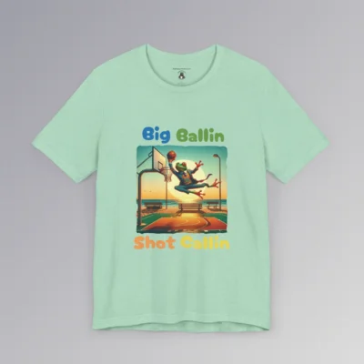 A heather mint colored shirt with a frog in a suit dunking a basketball, on a beach court with a big sun in the background, and the words "Big Ballin" above the graphic, and "Shot Callin" below the graphic. (Front of shirt).