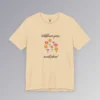 Soft cream colored t-shirt with blue, red, orange, and purple coneflower-like flowers, with green and mauve colored stems. In a handwriting font, is says "Wildflowers grow..." above the flowers, and "in wild places!" beneath the flowers.