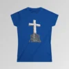 The front of a t-shirt with 3D text which states "The Rock On Which I Stand", from a slightly left perspective, in the shape of a simple house, with an old, wooden cross in the background. Color: Royal. Her Style.