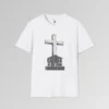 The front of a t-shirt with 3D text which states "Christ Is My Firm Foundation", from a slightly left perspective, in the shape of a simple house, with an old, wooden cross in the background. Color: White. His Style.