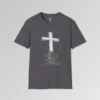 The front of a t-shirt with 3D text which states "The Rock On Which I Stand", from a slightly left perspective, in the shape of a simple house, with an old, wooden cross in the background. Color: Charcoal. His Style.