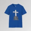 The front of a t-shirt with 3D text which states "The Rock On Which I Stand", from a slightly left perspective, in the shape of a simple house, with an old, wooden cross in the background. Color: Royal. His Style.