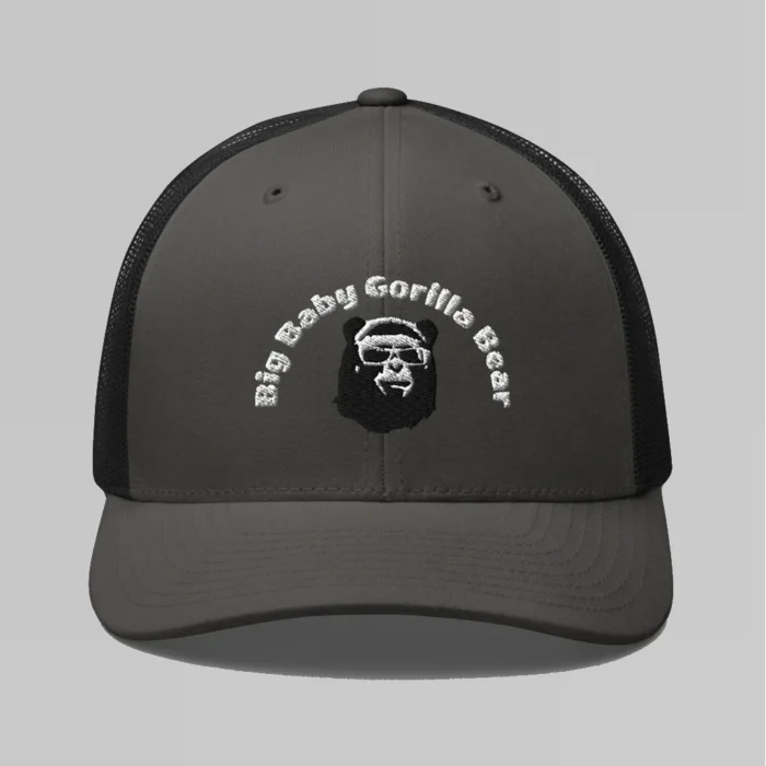 Front side view of a Charcoal and Black mesh trucker cap, with the Big Baby Gorilla Bear mascot's face and the Big Baby Gorilla Bear Name Embroidered in black and white on the front of the cap.