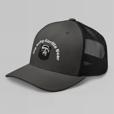 Left side view of a Charcoal and Black mesh trucker cap, with the Big Baby Gorilla Bear mascot's face and the Big Baby Gorilla Bear Name Embroidered in black and white on the front of the cap.