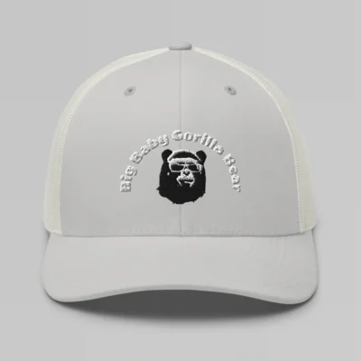 Front side view of a Silver mesh trucker cap, with the Big Baby Gorilla Bear mascot's face and the Big Baby Gorilla Bear Name Embroidered in black and white on the front of the cap.