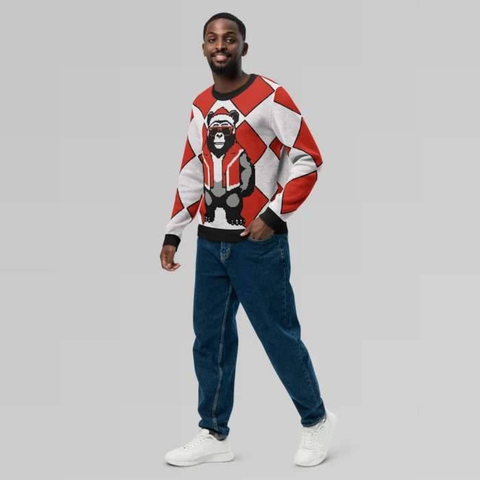 A male model showcasing the front and left side of a sweater with a red checkered knit sweatshirt with a slightly pixelated gorilla-bear hybrid (our mascot) on the front and back. The gorilla bear is wearing a Christmas Hat, Red shades, and a Santa hat.