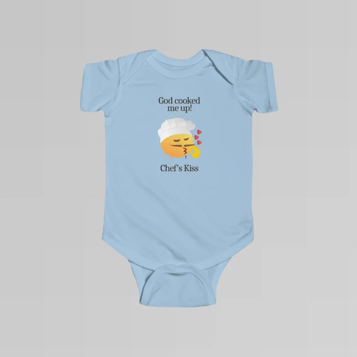 The front of a light blue colored baby onesie with the words "God cooked me up!" above a version of the Chef's Kiss emoji. Beneath the emoji, the words "Chef's Kiss" are written.