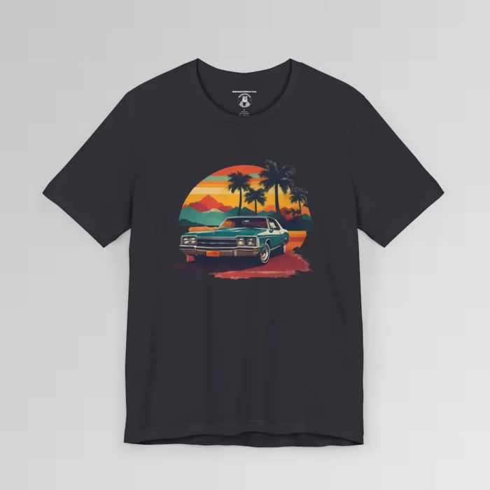 Front of a t-shirt with retro colors of orange, blues, browns, and yellows showing a classic blue-teal car, with palm trees, mountains, and a sky with the sun going down. Dark grey colored shirt.