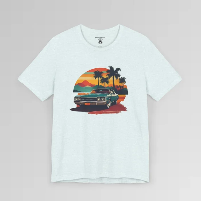 Front of a t-shirt with retro colors of orange, blues, browns, and yellows showing a classic blue-teal car, with palm trees, mountains, and a sky with the sun going down. Heather Ice Blue colored shirt.
