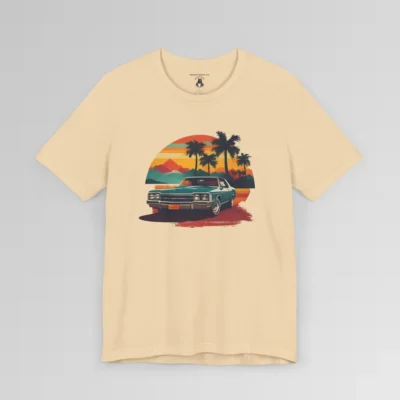 Front of a t-shirt with retro colors of orange, blues, browns, and yellows showing a classic blue-teal car, with palm trees, mountains, and a sky with the sun going down. Soft Cream colored shirt.