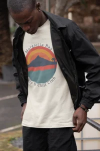 Male model with a black jacket and pants, and a natural colored "Margarita Bay" graphic tee from BigBabyGorillaBear.Com, in an outdoor setting.