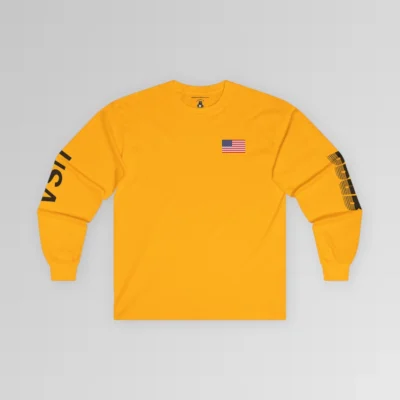 The frontside of the gold colored BBGB USA Full Stack Long Sleeve Tee, with an American Flag on the front left breast section, and the letters "USA" on the right sleeve, and "BBGB" on the left sleeve. The Letters "BBGB" have transparent lines going through the lower portion of the letters.