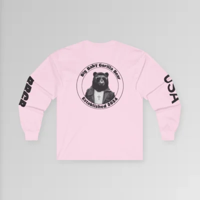 A pink colored long sleeved tee, highlighting the backside of the BBGB USA Full Stack Long Sleeve Tee. The backside has the BBGB Logo super-imposed on the upper back portion of the shirt, and the the letters "USA" and BBGB" on the sleeves. The "BBGB" letters has lines going through each letter, adding a trendy blind appearance to the bottom half of the lettering.