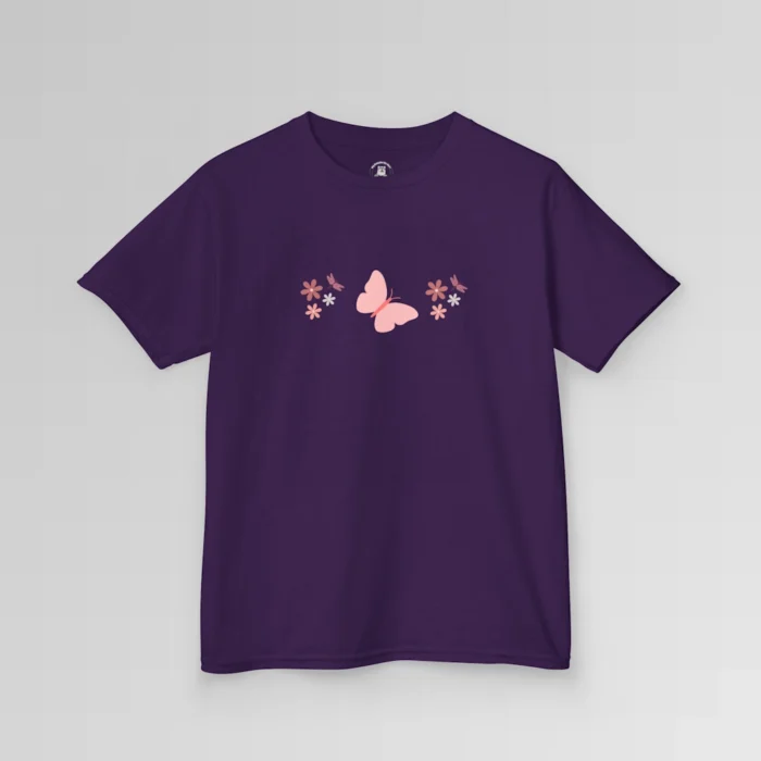 A purple colored shirt with a pink butterfly with a coral-colored body in the center, and pink, white, and blush colored flowers, and blush colored dragonflies...in a pattern going vertically across the tee. Child's Version.