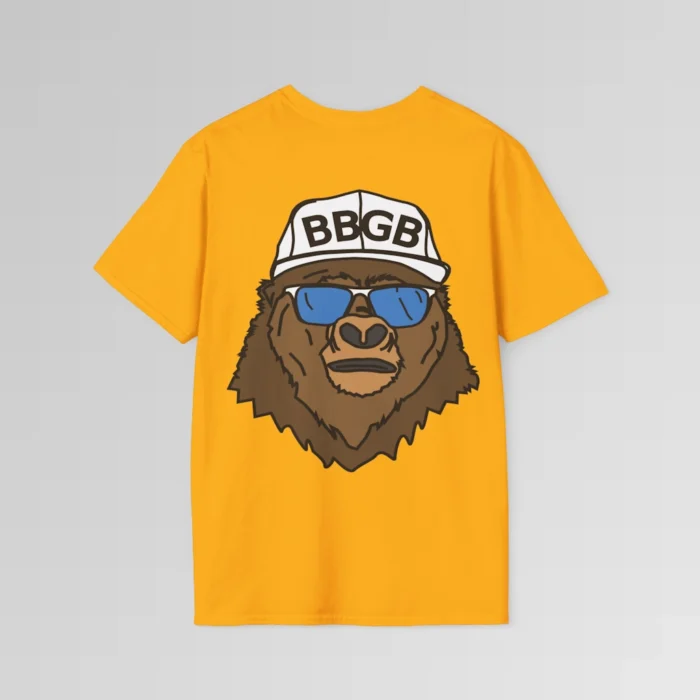 The back of a gold colored shirt, with the Big Baby Gorilla Bear Mascot's face, wearing a white ball cap, and blue and white shades, super imposed on the back of a tee shirt.