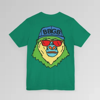 The back of a kelly colored shirt, with the Big Baby Gorilla Bear Mascot's face in vibrant colors of light blue, green, yellow, and orange, wearing a blue ball cap, and red shades, super imposed on the back of a t-shirt.