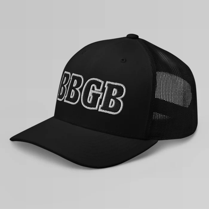 A black hat with the letters "BBGB" embroidered on the front in black thread, with a white border, on a trucker cap with a mesh back. (Left Side View)