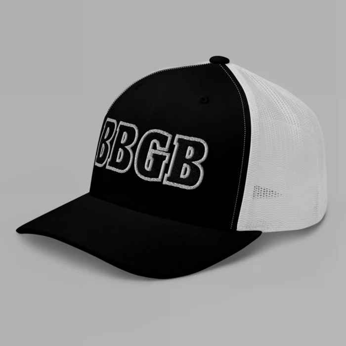 A black and white hat with the letters "BBGB" embroidered on the front in black thread, with a white border, on a trucker cap with a mesh back. (Left Side View)