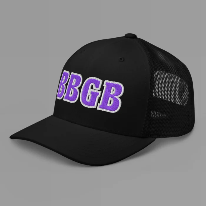 A black hat with the letters "BBGB" embroidered on the front in purple thread, with a white border, on a trucker cap with a mesh back. (Left Side View)