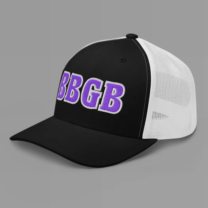 A black and white hat with the letters "BBGB" embroidered on the front in purple thread, with a white border, on a trucker cap with a mesh back. (Left Side View)